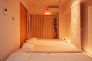 two beds in a room with a window at HISASHI 池下 in Nagoya
