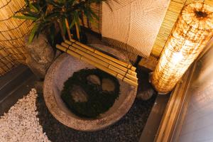 a bowl with a plant and some bamboo sticks at HISASHI 池下 in Nagoya