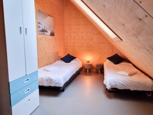 twee bedden in een kamer met een zolder bij Vakantiewoning Lux Dune Oostkapelle OK47 in Oostkapelle