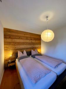 two beds in a bedroom with a wooden wall at Ferienwohnung Magma in Lutzerath