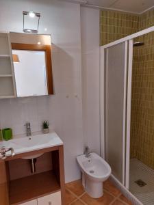 uma casa de banho com um lavatório, um chuveiro e um WC. em Vakantiewoning Melrose Place - Mil Palmeras - 900 m van zee em Campoamor