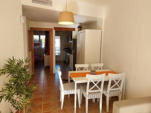 uma cozinha e sala de jantar com mesa e cadeiras em Vakantiewoning Melrose Place - Mil Palmeras - 900 m van zee em Campoamor