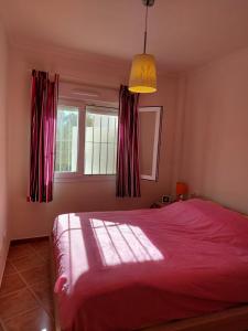um quarto com uma cama vermelha e uma janela em Vakantiewoning Melrose Place - Mil Palmeras - 900 m van zee em Campoamor