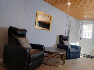 a living room with two chairs and a table at Red Island Cozy Casa in Summerside