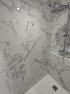 y baño de mármol con ducha y lavabo. en Studio Haut De Bordagain Ciboure, en Ciboure