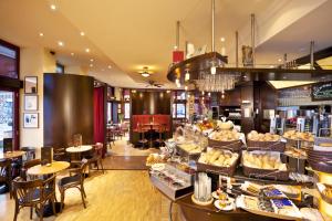 ein Restaurant mit Tischen und Stühlen und eine Bäckerei in der Unterkunft Best Western Hotel Hohenzollern in Osnabrück