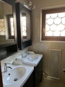 a bathroom with two sinks and a window at Haus JoLoMo in Mallnitz