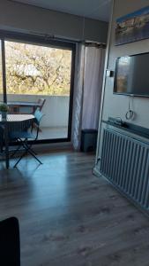sala de estar con mesa y ventana grande en Studio Haut De Bordagain Ciboure, en Ciboure