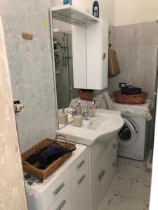 La salle de bains est pourvue d'un lavabo, d'un miroir et d'un lave-linge. dans l'établissement Villetta Carmelo, à San Pietro in Bevagna