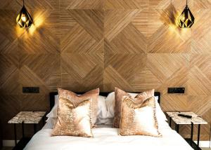 a bedroom with a wooden wall with a bed with pillows at Goosedale Lodges in Nottingham