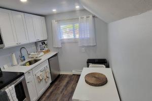 una cocina con armarios blancos y una mesa con sombrero. en Cheerful 2-Bedroom Apartment with Smart Home Tech., en Uniondale