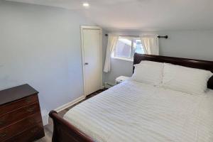 1 dormitorio con 1 cama, vestidor y ventana en Cheerful 2-Bedroom Apartment with Smart Home Tech., en Uniondale