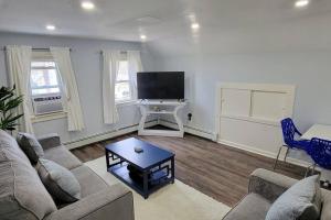 sala de estar con sofá y TV en Cheerful 2-Bedroom Apartment with Smart Home Tech., en Uniondale