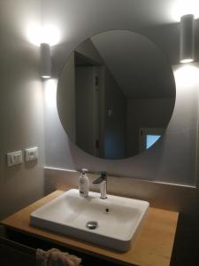 uma casa de banho com um lavatório e um espelho redondo em Casa Bonita, nel cuore di Bologna em Bolonha