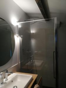 uma casa de banho com um lavatório e um chuveiro com um espelho. em Casa Bonita, nel cuore di Bologna em Bolonha