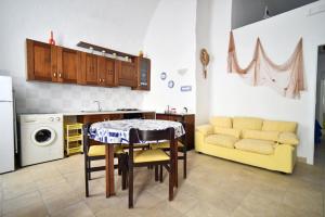 a kitchen with a table and a couch in a room at Camera vista mare Holidayz in Gallipoli