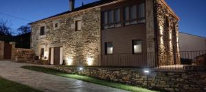 a stone building with lights on the side of it at Caraxolas in Lugo