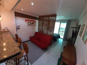 a living room with a red couch and a table at Camboinhas LOFT Temporada in Niterói