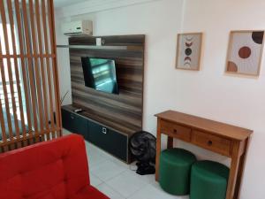 a living room with a red couch and a television at Camboinhas LOFT Temporada in Niterói