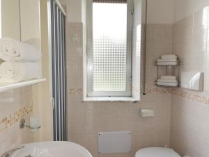 bagno con servizi igienici, lavandino e finestra di Le Zagare Case Vacanza a Cropani