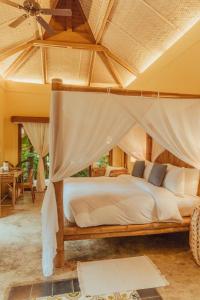 a bedroom with a bed with a canopy at INARA Siargao in General Luna