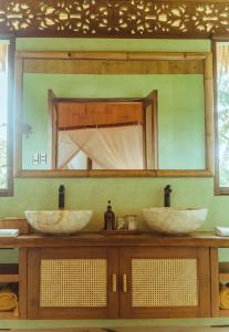 a bathroom with two sinks and a large mirror at INARA Siargao in General Luna