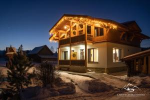 a house with christmas lights on top of it at Apartments Chalet Girska Hatyna in Vorokhta
