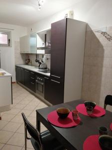 a kitchen with a black table with two red plates at 1000MigliaHouse in Brescia