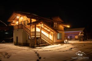 a house in the snow at night at Apartments Chalet Girska Hatyna in Vorokhta