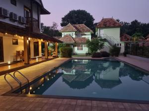 a villa with a swimming pool at night at Vajra Ayurveda and Yoga Retreat in Cochin