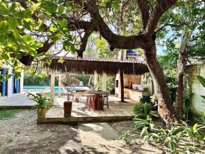 a house with a patio with a table and a tree at Casa Bonita da Barra - 04 quartos, 170m da praia barramar in Barra de São Miguel +39 photos