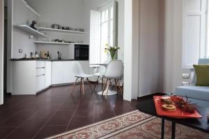a kitchen and living room with white cabinets and a table at Carolina's Nest in Trapani