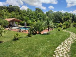 un jardín con un camino que conduce a una piscina en Charmant T2 avec piscine entre mer et montagne en Ibarron