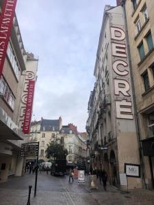 a city street with buildings and people walking on the street at Le Pillow Rit in Nantes