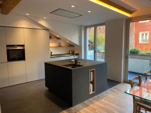 a kitchen with a black island in the middle at Apartment Obstplatz - Free Parking & AC in Bolzano