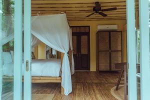 a bedroom with a bed with a ceiling fan at INARA Siargao in General Luna