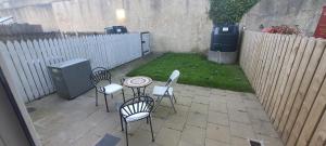 um pátio com uma mesa, cadeiras e uma cerca em Carrick-On-Shannon Townhouse Accommodation - Room only em Carrick on Shannon