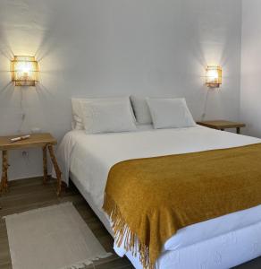 um quarto com uma cama grande e 2 candeeiros em Quinta do Castelo em Beja