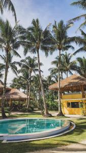 a swimming pool in front of palm trees at INARA Siargao in General Luna