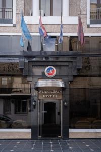 - un bâtiment avec un panneau et des drapeaux d'hôtel dans l'établissement Hotel Marilian, à Salta