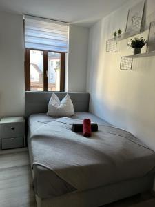 a bedroom with a bed with a red sock on it at Gästehaus Glücksmoment in Erfurt