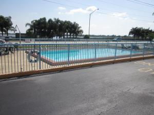 a swimming pool with a fence next to a street at Westmont Inn - Lakeland in Lakeland