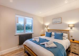 a bedroom with a large bed with blue pillows at Hambleton Lakeside Lodges in Poulton le Fylde