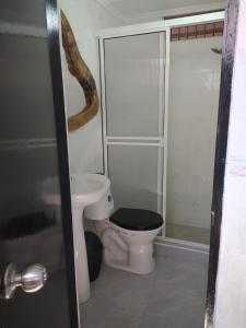 a bathroom with a toilet with a black seat at Hermoso apto a una cuadra de la playa rodadero in Gaira