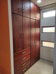 un armario con armarios de madera y una ventana en Departamento amueblado moderno, en Manta