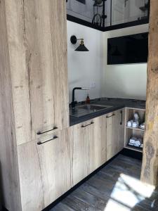 a kitchen with wooden cabinets and a sink at La Grange de la Maison des chats - Gîte en Quercy in Saint-Amans-du-Pech