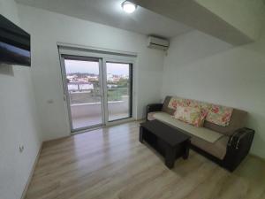 a living room with a couch and a large window at AS Apartments in Ulcinj