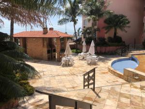 a courtyard with a pool and tables and a building at Porto das Dunas in Aquiraz