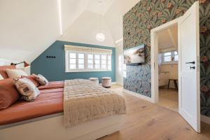 ein Schlafzimmer mit einem großen Bett mit einer blauen Wand in der Unterkunft Haus Süderjen in Westerland