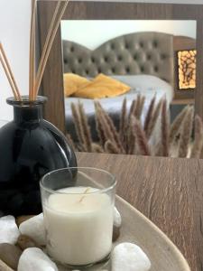 a candle and a vase sitting on a table at Asitad DeLuxe Apartments in Ruse